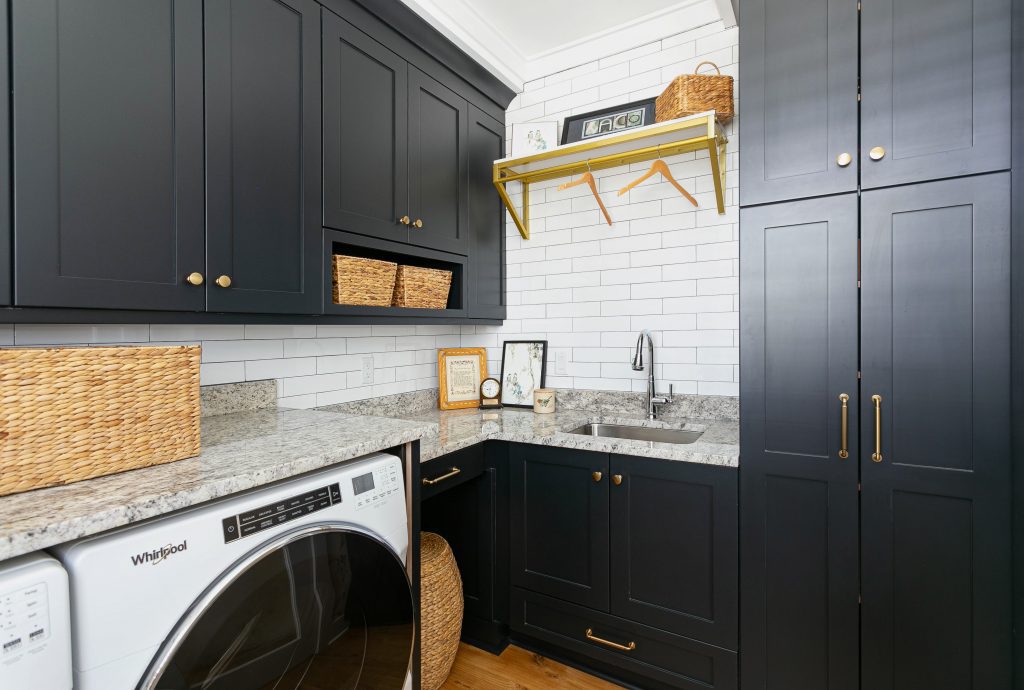 Classic cottage laundry room features a white and gray granite